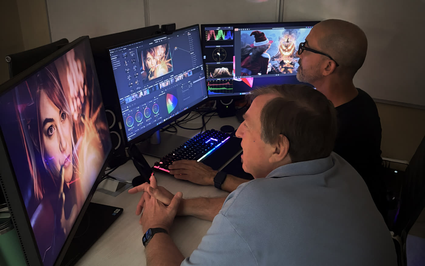 Two colourists at a DaVinci Resolve suite, the Merry poster artwork up on the reference monitor beside the scopes.