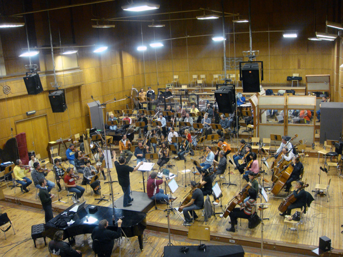 A full orchestra recording a film score on the scoring stage.