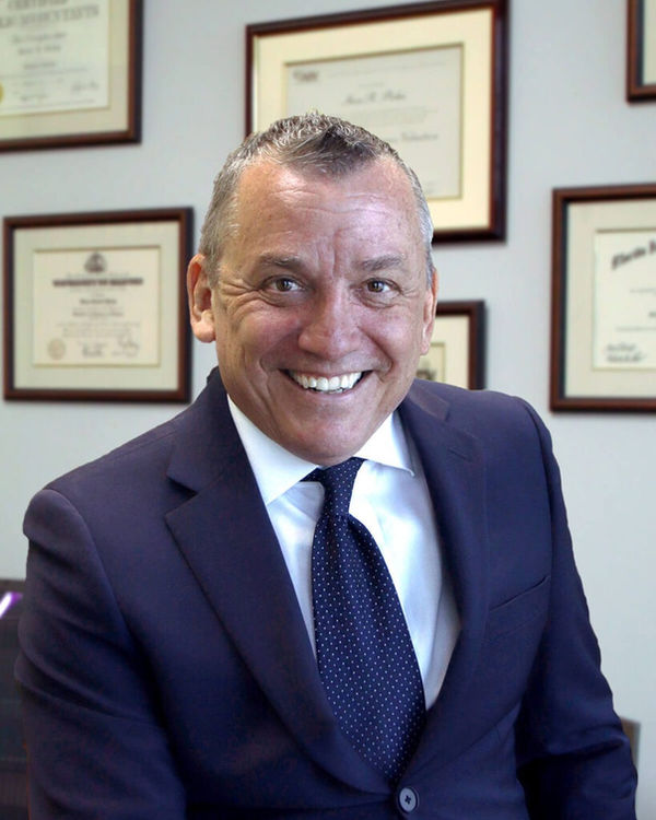 Steve R. Picha, seated in his office in a navy suit.