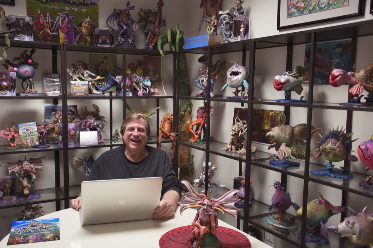 Tom Walsh at his desk in the character library, shelves of sculpted creatures on every side.
